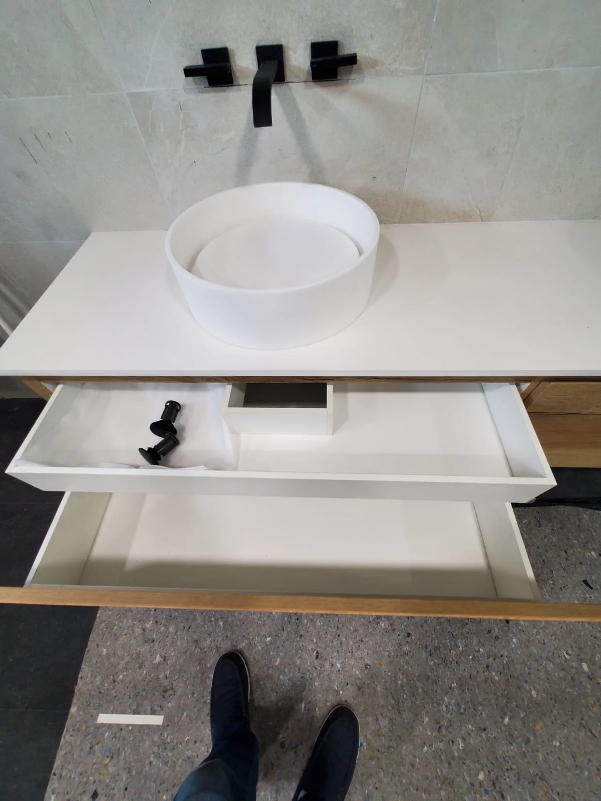 Vanity detail with hidden drawer under a vessel sink